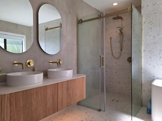 Modern bathroom with walk-in shower tiled in porcelain terrazzo-style tiles – project in Browns Bay by Direct Tiling