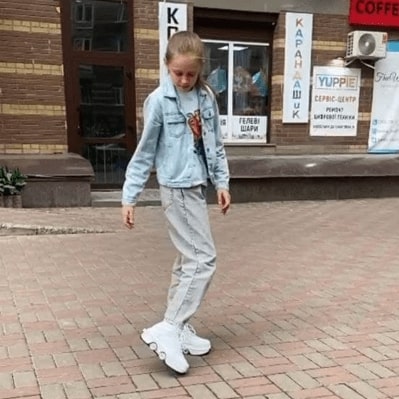 На фото девочка обута в белые роликовые кроссовки